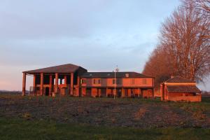 ein großes Haus auf einem Feld in der Unterkunft Agriturismo Ferrara Chalet in Vigarano Mainarda