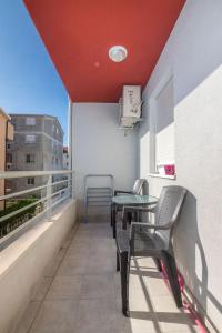 a balcony with a table and chairs on a building at Apartment Matmar in Split
