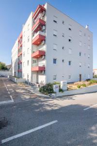 an empty parking lot next to a white building at Apartment Matmar in Split