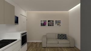 uma sala de estar com um sofá e uma cozinha em Piccolo Moderno Appartamento sulla Spiaggia in Centro em Lido di Jesolo