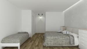 um quarto com 2 camas e uma parede branca em Piccolo Moderno Appartamento sulla Spiaggia in Centro em Lido di Jesolo