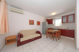 a kitchen with a couch and a table in a room at Apartments Karolina in Novalja