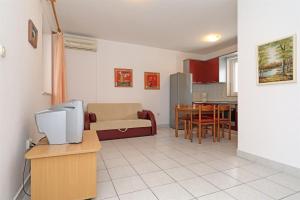 a living room with a couch and a dining room at Apartments Karolina in Novalja