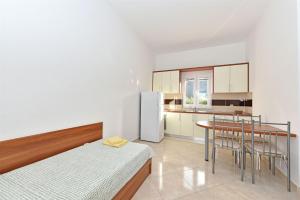 a kitchen with a bed and a table in a room at Apartments Karolina in Novalja