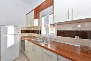 a kitchen with white appliances and a wooden counter top at Apartments Karolina in Novalja