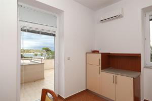 a kitchen with a counter and a window with a view at Apartments Karolina in Novalja