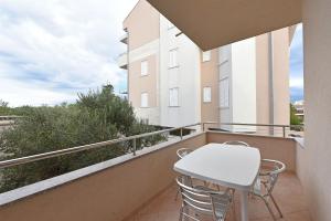 a balcony with a white table and chairs at Apartments Karolina in Novalja