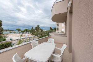 a balcony with a table and chairs and a view of the beach at Apartments Karolina in Novalja