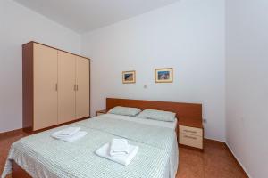 a bedroom with a bed with two towels on it at Apartments Karolina in Novalja