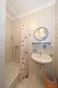 a bathroom with a tub and a sink and a shower at Apartments Karolina in Novalja