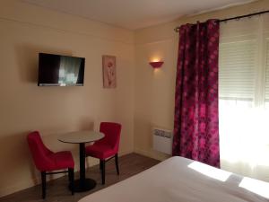 Habitación con mesa, 2 sillas y 1 cama en Hotel Les Rocailles, en Montagnac
