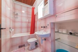 La salle de bains est pourvue d'un lavabo, de toilettes et d'une baignoire. dans l'établissement Apartment Lidija, à Tisno