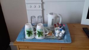 a table with a blender and cups on it at Camillia Guest House in Aberdeen