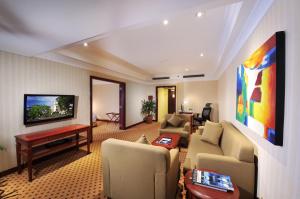 a living room with couches and a flat screen tv at Hotel Borobudur Jakarta in Jakarta