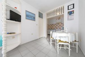 a white dining room with a white table and chairs at Apartments Danica in Tisno