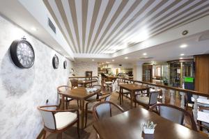 restauracja ze stołami i krzesłami oraz zegarem na ścianie w obiekcie Oca Ipanema Hotel w mieście Vigo