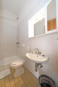 a white bathroom with a toilet and a sink at Rooms Jeriko in Vodice +45 photos