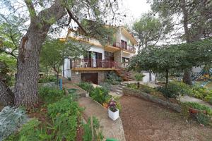 a house with a balcony and a yard with plants at Rooms Jeriko in Vodice