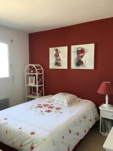 a bedroom with a bed with three pictures on the wall at Appartement, vue mer à 150m de la plage in Trouville-sur-Mer