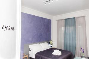 a bedroom with purple walls and a bed with white pillows at Foresteria Boccadasse in Genoa