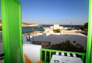 a green balcony with a view of the ocean at Kastellos Apartments Sikinos in Alopronia