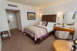 a hotel room with a bed and a desk at Swan's Nest Hotel in Stratford-upon-Avon