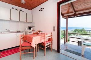 a kitchen with a table and a view of the ocean at Apartments Ilinka in Lovran