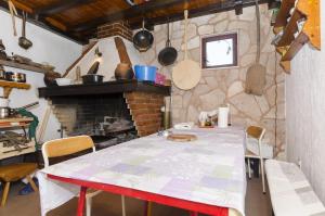 a kitchen with a table and a brick fireplace at Apartments and Room Villa Niko in Bol