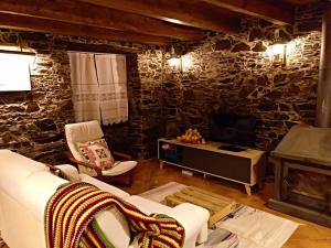a living room with a stone wall at Talasnal Casa do Cascão in Lousã