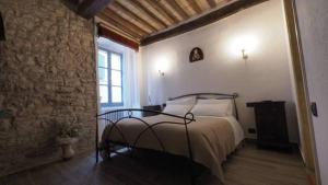 1 dormitorio con cama y pared de ladrillo en Affittacamere In Centro en Gubbio