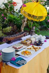 a table with plates of food and an umbrella at Cocotinos Sekotong Lombok in Sekotong