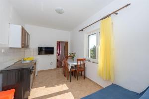a small kitchen with a table and a window at Apartments Ivan in Vrsi
