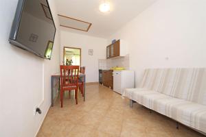 a living room with a couch and a kitchen at Apartments Ivan in Vrsi