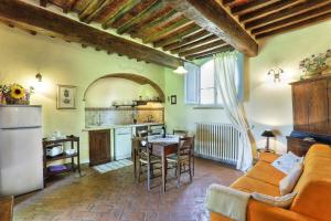 a kitchen and living room with a couch and a table at Via della Stella in Valiano