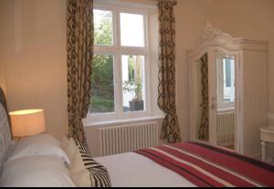 1 dormitorio con cama y ventana en Haldon Priors, en Torquay