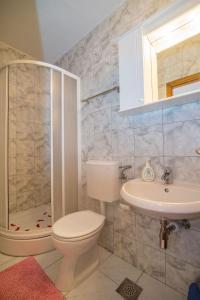 a bathroom with a toilet and a sink and a shower at Apartment and Rooms Ruza in Trogir