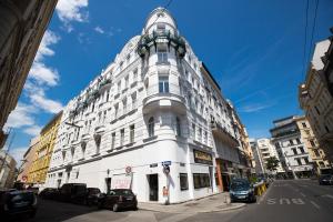 ein weißes Gebäude mit einer Uhr oben drauf in der Unterkunft GRAND SOHO II Apartment Vienna in Wien