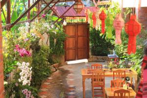 a patio with a wooden door and a table and chairs at Boutique House Nipha in Chiang Mai
