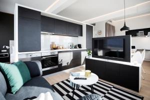 uma sala de estar com um sofá e uma televisão em PhilsPlace Full-Service Apartments Vienna em Viena