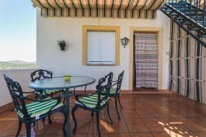 einen Tisch und Stühle auf einer Veranda mit einer Treppe in der Unterkunft Agroturismo Ecologico el Cortijillo in Luque