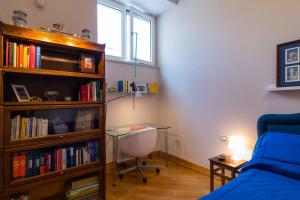 a room with a book shelf with books and a desk at Elegant Flat at Municipio by Napoliapartments in Naples