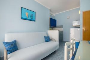 a living room with a white couch and a refrigerator at Apartments Mirjana in Marina
