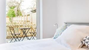 Un dormitorio con una cama y un balcón con una mesa. en The Wing -Near to the beaches and Bournemouth University, en Bournemouth