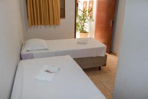 a room with two beds and two tables in it at Hotel Jeremias in Barretos