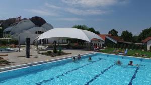 a group of people swimming in a swimming pool at Hőforrás Hotel in Gyula