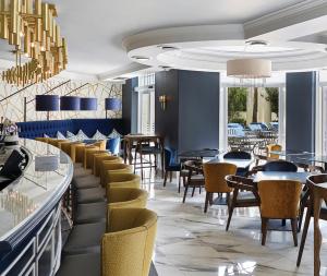 a restaurant with chairs and tables and a bar at Southern Sun The Cullinan in Cape Town