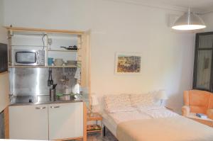 a small room with a bed and a microwave at Heliópolis I in Seville