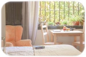 a room with a table and a chair and a window at Heliópolis I in Seville