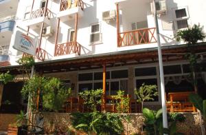 a building with tables and chairs in front of it at Rain Hotel in Kizkalesi