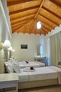 1 Schlafzimmer mit 2 Betten und Holzdecke in der Unterkunft Element Hotel in Elafonisos